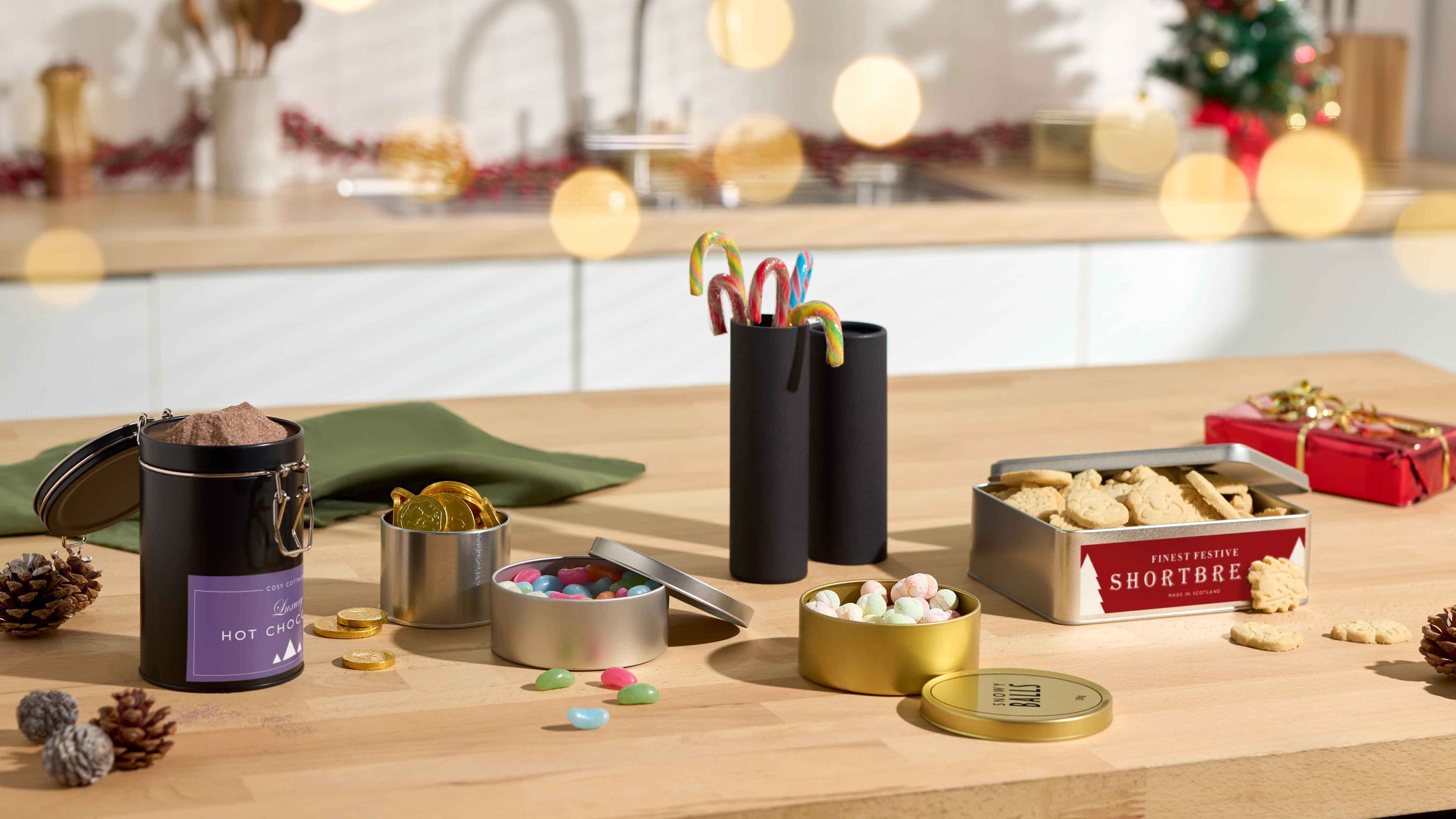 Decorative sweet packaging on a table with a Christmas tree in the background