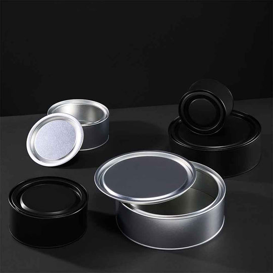 Wider lever lid tins on a grey background in silver and black. 